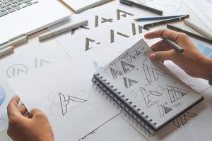 Graphic designer drawing sketch design creative Ideas draft Logo product trademark label brand artwork. Graphic designer studio Concept.